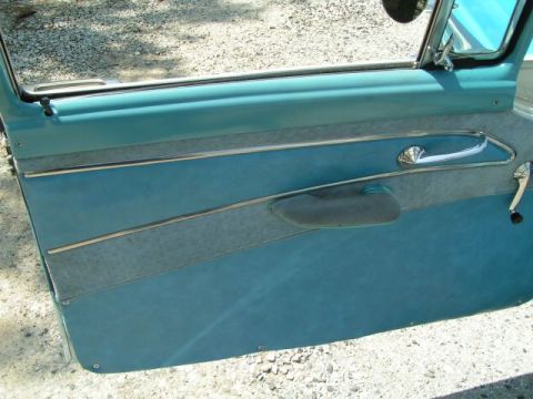 1956 Ford Fairlane - Interior view of a 1956 Ford Fairlane door panel, showing the blue upholstery and chrome accents.