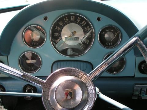 1956 Ford Fairlane - The interior of a 1956 Ford Fairlane features a distinctive dashboard with a central speedometer and auxiliary gauges.