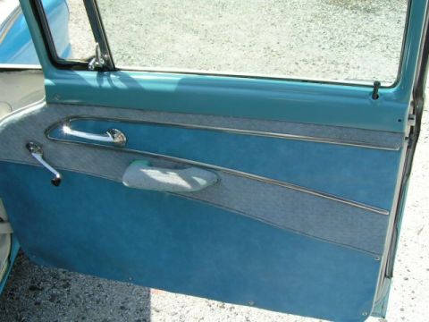 1956 Ford Fairlane - The interior door panel of a 1956 Ford Fairlane features a two-tone design with blue vinyl and grey fabric.