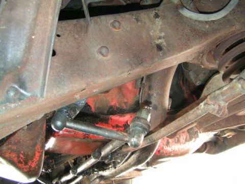 1956 Ford Fairlane - The rusty frame and suspension parts suggest this vehicle is quite old and may require significant restoration.