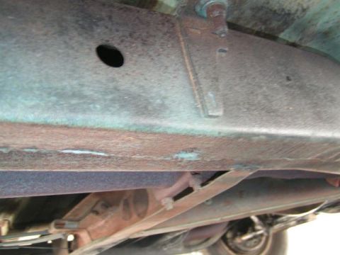 1956 Ford Fairlane - Undercarriage view shows a rusty frame and exhaust system, with no clear year identification.