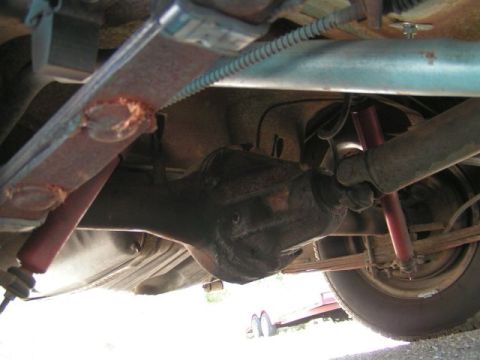 1956 Ford Fairlane - Underside view of a vehicle's rear axle, leaf springs, and shock absorbers.