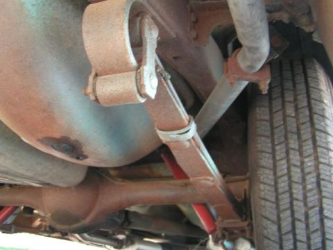 1956 Ford Fairlane - A close-up view of the undercarriage reveals leaf springs and a tire, showing the vehicle's suspension components.
