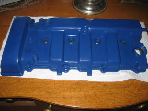 1993 Ford Probe - A freshly painted blue valve cover rests on paper towels on a wooden surface.