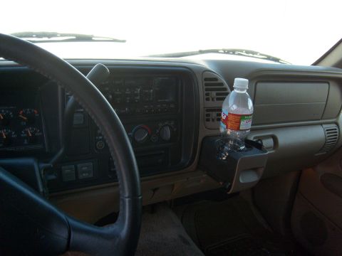 1995 Ford C-350 (Centurion Conversions) - The interior of a vehicle, showing the dashboard, steering wheel, and a water bottle placed in the cup holder.