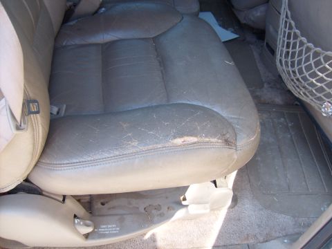 1995 Ford C-350 (Centurion Conversions) - The interior of the vehicle shows a driver's seat with significant wear and tear on the leather upholstery.