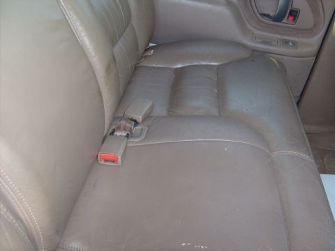 1995 Ford C-350 (Centurion Conversions) - Interior view of worn tan leather rear car seats with seatbelts.