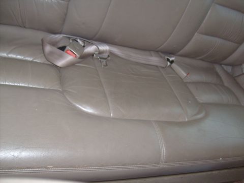 1995 Ford C-350 (Centurion Conversions) - Rear seating area of a 1995 Ford C-350 (Centurion Conversions) tan leather upholstery and a seatbelt.