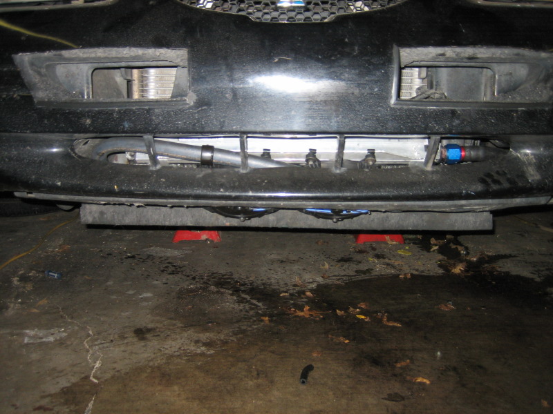Car front end on jack stands, showing intercooler and custom plumbing