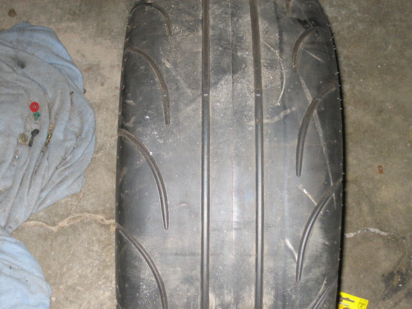Tire tread on concrete floor next to a blue cloth with tools