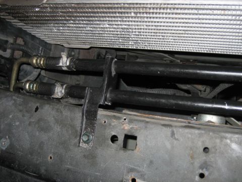 1996 Ford Thunderbird - Close-up of vehicle's radiator and AC condenser lines, showing connections and mounting bracket.