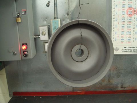 1996 Ford Bronco - A grinding wheel hangs from a wire in front of a control panel and a chart.