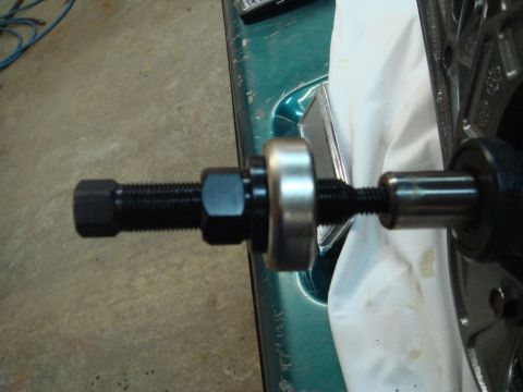 1996 Ford Bronco - A tool is shown removing a pulley from a power steering pump, with part of a green vehicle visible in the background.