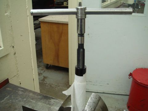 1996 Ford Bronco - A reamer tool with a T-handle is shown, with a paper towel wrapped around its shaft.