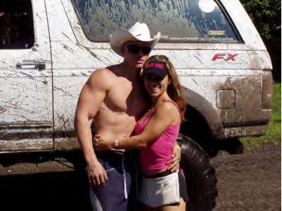 1995 Ford Bronco - A couple poses in front of a heavily muddied white SUV, likely after an off-roading adventure.