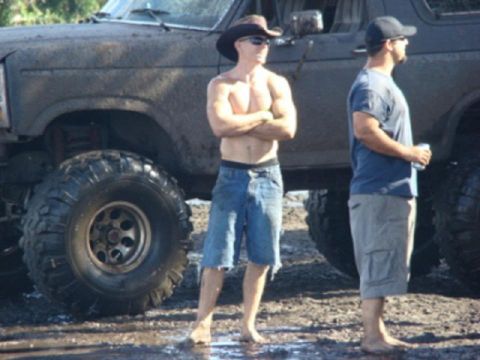 1995 Ford Bronco - Two men stand next to a lifted 1995 Ford Bronco with large off-road tires.