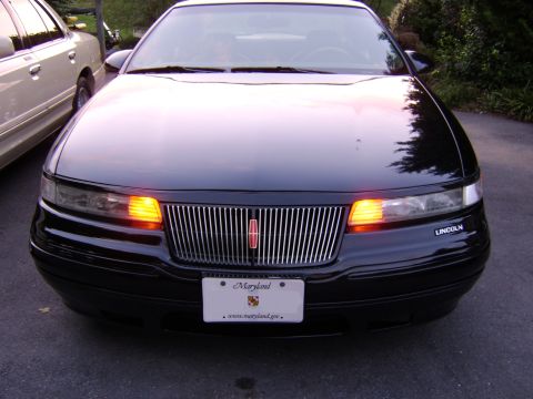 1996 Mercury Grand Marquis - The front view of a black Lincoln Mark VIII, parked next to another vehicle.