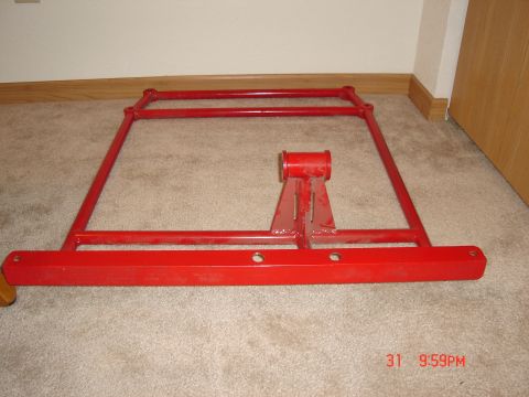 1993 Ford Probe - A red metal frame, possibly a jack stand or part of a lift, is shown on a carpeted floor.