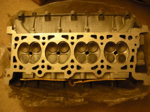 1998 Ford Crown Victoria - Combustion-chamber face of an aluminum overhead-cam cylinder head resting on packaging.