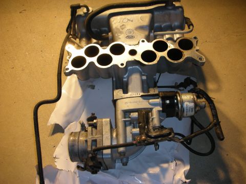 1998 Ford Crown Victoria - Aluminum upper and lower intake manifold with throttle body and fuel lines laid out on packaging.