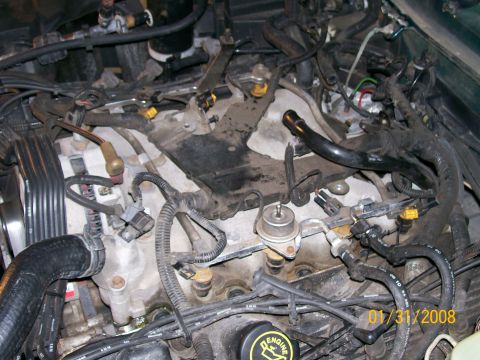 1995 Mercury Grand Marquis - Overhead view of a V8 engine bay with the upper intake manifold removed, exposing the aluminum lower intake, fuel rails, injectors and the…
