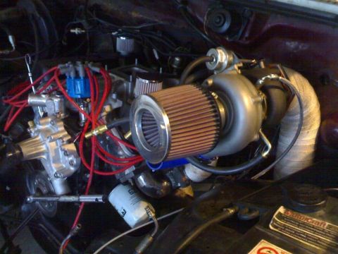1985 Ford Bronco - Close-up of a modified engine bay a turbocharger and custom air intake system.