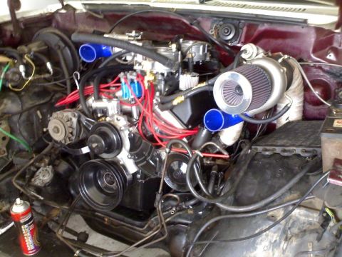 1985 Ford Bronco - The engine bay shows a modified engine with a turbocharger and custom piping.