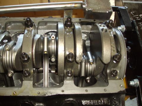 1985 Ford Bronco - Close-up view of an engine's crankshaft and connecting rods, with a watermark indicating 'SUPERMOTORS'.