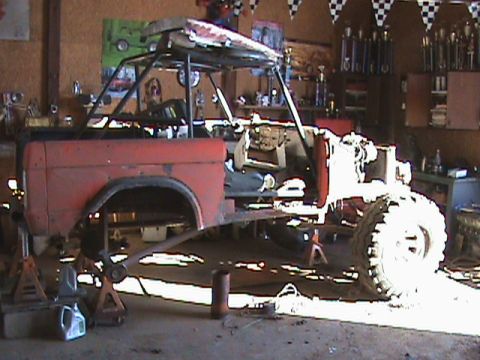 1967 Ford Bronco - This vehicle is undergoing modifications in a garage setting, with the engine removed and a roll cage installed.