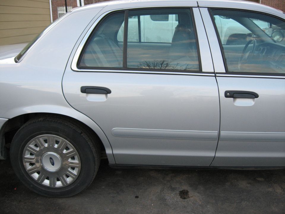 Silver 2004 Ford Crown Victoria side view showing rear door and wheel