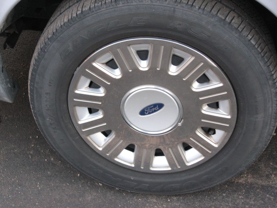 Close-up of a Ford wheel with a silver hubcap and a blue Ford logo