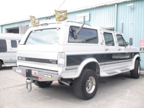 1993 Ford C-350 (Centurion Conversions) - This Ford Bronco SUV has a custom rear bumper and two flags mounted on the roof.