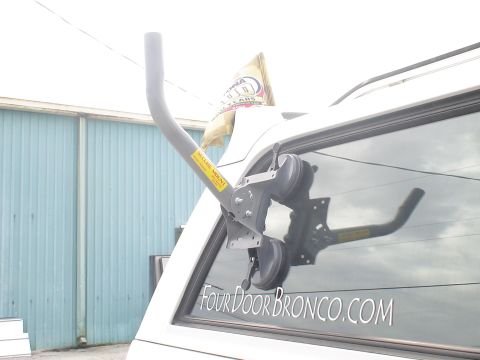 1993 Ford C-350 (Centurion Conversions) - A suction cup mount is attached to the rear window of a white SUV, with a satellite dish arm extended.