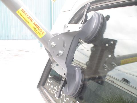 1993 Ford C-350 (Centurion Conversions) - A Secure Mount device is attached to a vehicle's rear window, which has 'FOUR DOOR' lettering visible.