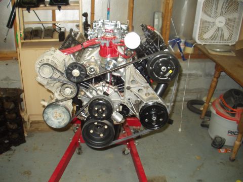 1993 Ford Bronco - Engine assembly on a stand, multiple belts and pulleys, ready for installation.