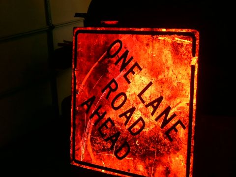1978 Ford Bronco - A weathered road sign with the message "ONE LANE ROAD AHEAD" is illuminated by a red light.