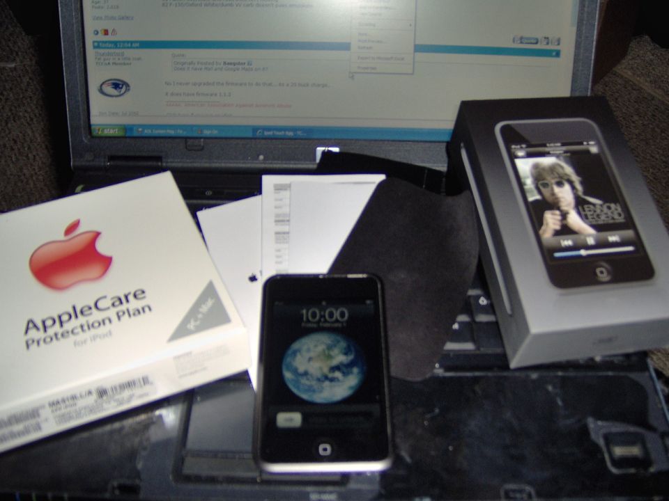 AppleCare box, two iPods, and a laptop on a keyboard. One iPod is in its box