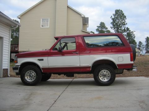 1995 Ford Bronco - Side view of a two-tone red and white 1995 Ford Bronco SUV.