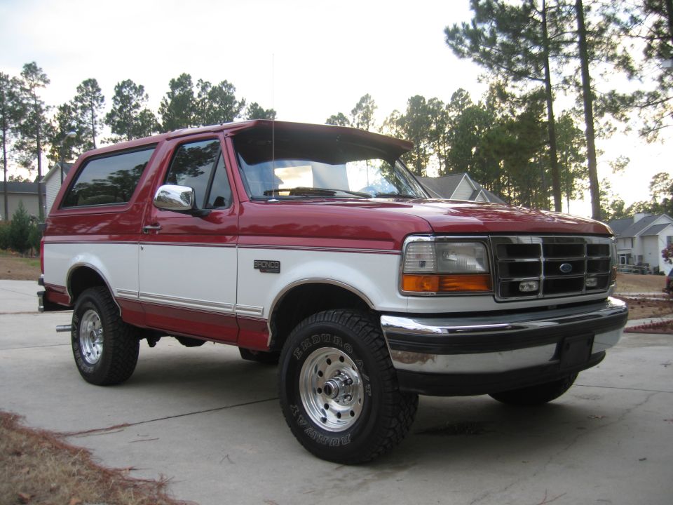 Red and white Ford Bronco parked on a driveway