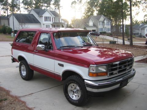1995 Ford Bronco - This two-tone Ford Bronco is parked in front of suburban houses.