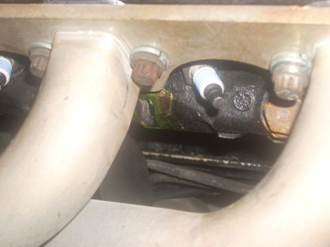1991 Ford Mustang - Engine detail showing exhaust manifold, spark plugs, and signs of fluid leakage.