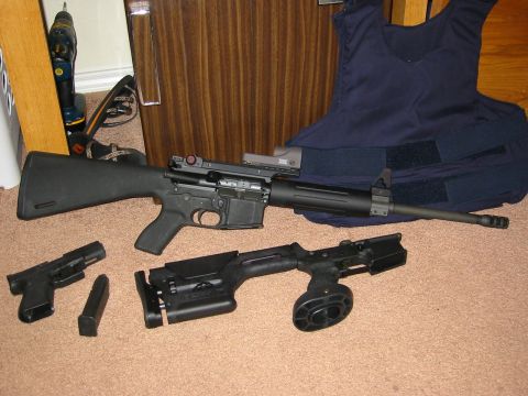 1996 Ford Bronco - Various firearms and protective gear are displayed on a carpeted floor.