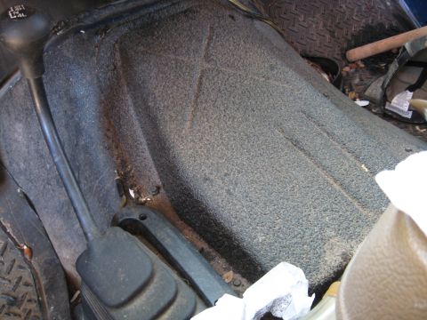 1990 Ford Bronco - The interior floor console shows a 4-wheel drive shifter and a textured surface, with some debris visible.