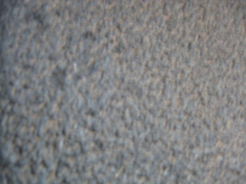 Close-up of gray carpet texture with dark speckles