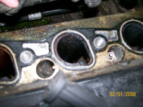 1995 Mercury Grand Marquis - Engine intake manifold gasket area shows wear and tear, with carbon buildup and oil residue.