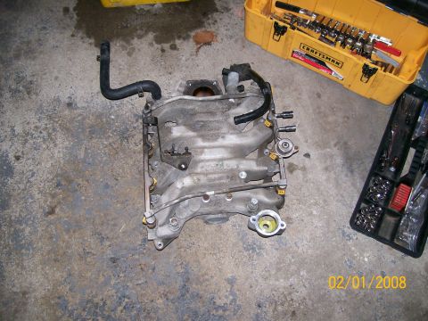 1995 Mercury Grand Marquis - A disassembled engine part, likely an intake manifold, is shown with tools nearby.