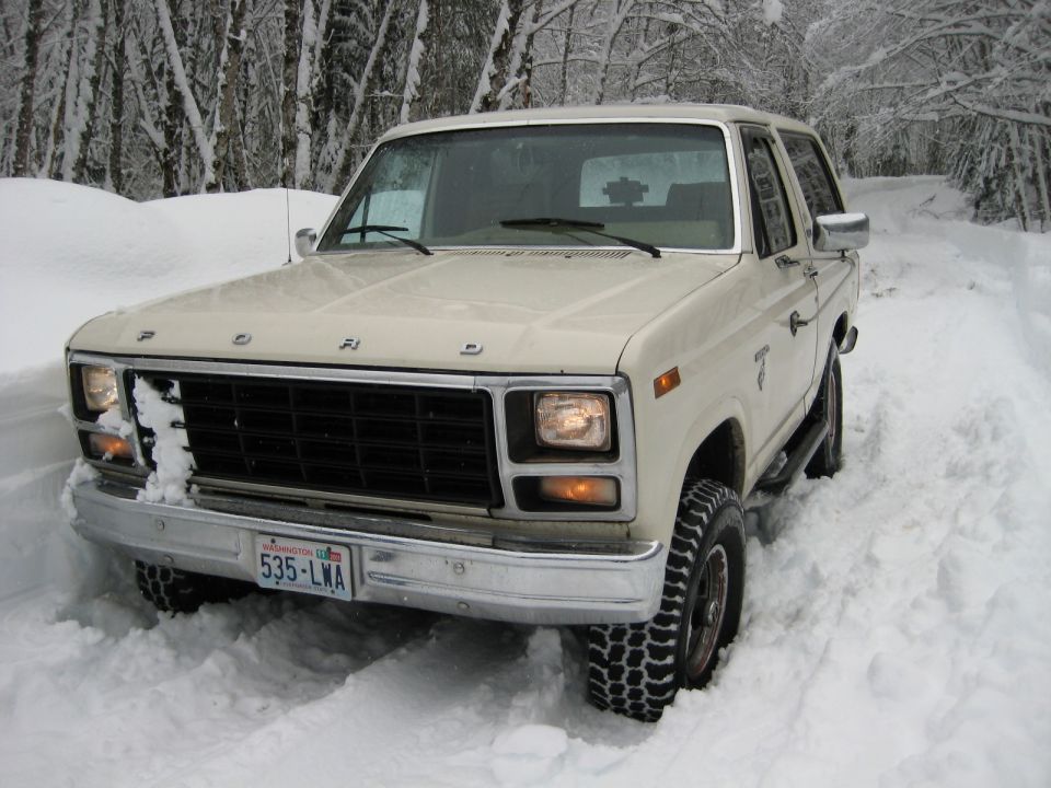 Tan Ford Bronco with Washington plate 535-LWA parked in deep snow on a tree-lined road