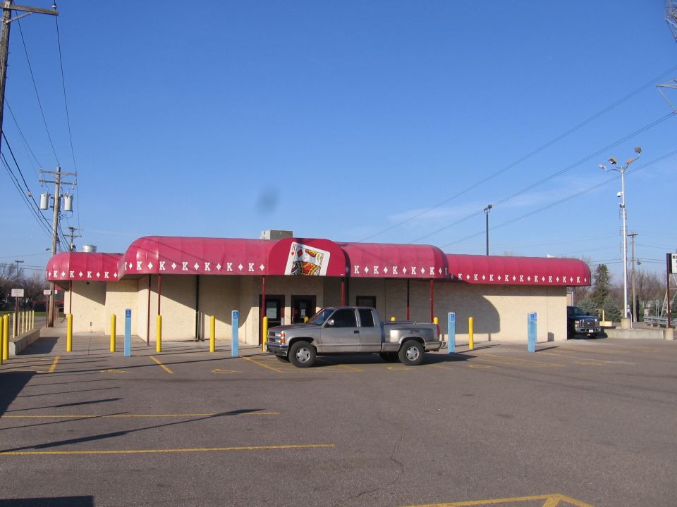 Tan building with red playing-card awning and parked truck