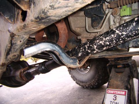 2003 Jeep Wrangler - Close-up view of the undercarriage of a vehicle, highlighting suspension and drivetrain parts.