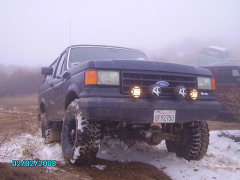 1990 Ford Bronco - Front view of a modified 1990 Ford Bronco in a snowy, foggy outdoor setting.